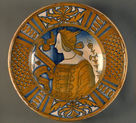 Large dish with segmental border of plant sprays and scale pattern; in the center, a profile bust of a woman in a winged headdress