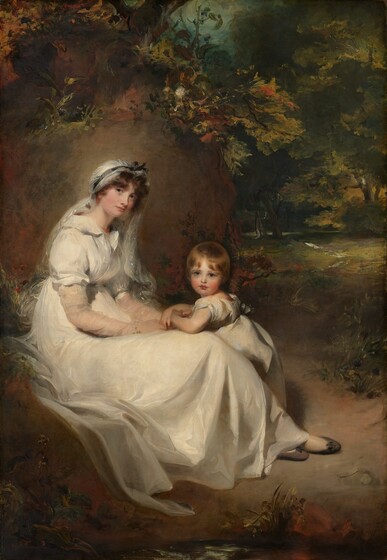 Both dressed in white, a little boy leans onto the lap of a woman sitting in front of a smooth, sunlit boulder with a landscape to the right in this vertical portrait painting. Both people have pale skin with rosy cheeks. To our left, the woman sits with her body facing our right. Her round face also tips to our right, and she looks at us with gray eyes. She has an upturned nose and her full, pink lips are closed in a slight smile. Her long legs are crossed at the ankles, and dark gray slippers peek out from under the long hem. She wears a diaphanous, eggshell-white gown gathered under her bust. The short sleeves of the dress are puffy over sheer sleeves that extend to her wrists. A sheer veil is tied over her brown hair with a gray ribbon falls over her shoulders. She wears coral-red beaded necklace and drop earrings. Her hands rest in her lap and intertwine with the little boy’s hands. He stands behind her and leans onto her knees with both elbows. His round face is framed by a cap of honey-brown hair, and he looks at us with big, lapis-blue eyes. The boy has a small nose and bow-shaped lips. He wears a flax-yellow and mist-gray short sleeved garment with a bow in the back. Light falls on the pair from our left, and throws some of the foliage surrounding them into shadow. Burnt orange, gold, and white leaves and flowers surround the boulder behind the woman, and a view into a moss-green forest interior extends into the distance to our right.
