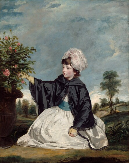 A young girl with dark hair and pale skin, wearing a long white dress, kneels on the ground in a hilly, tree-lined landscape in this vertical portrait painting. The girl sits close to us, her body slightly angled to our left as she looks toward and reaches for a rose bush potted in a tall, brown urn along the left edge of the painting. She has pale gray eyes under faint brows and a delicate, pointed nose. Her round cheeks are flushed, and her pink bow lips are closed. Her chestnut-brown hair curls at the neck of her clothing, and bangs cover her forehead under a lacy white bonnet. Light glistens off her lace-edged black cape, which is tied at her throat. The full skirt of her white dress pillows like a cloud on the ground around her legs, and she has a wide, teal-blue sash around her waist. With her right arm, farther from us, she reaches out to touch a pink blossom with a gloved hand. The fingers of the butter-yellow gloves have been folded back. Her other hand rests with exposed fingers in a loose fist in near her knee. Behind her, gently rolling hills are dotted with leafy green trees silhouetted against a stretch of white sky just above the low horizon. Painted in smoky gray, ivory white, and pale, blush pink, the thin clouds against the topaz-blue sky fills the upper two-thirds of the picture. The painting is inscribed with gold paint in the lower right corner: “Lady Caroline Howard” and “Lady Cawdor.”