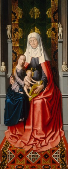 Two women and a baby, all with pale skin, sit together on a gray, stone throne with patterned fabric hanging behind them and a patterned rug below in this narrow, vertical painting. The woman sitting on the throne, Saint Anne, is the largest. A second woman, Mary, is smaller in scale, and she sits on Saint Anne’s lap. Mary, in turn, holds a nude baby boy on her lap. Both women have light brown eyes under faint, arched brows, smooth skin, long straight noses, and their shell-pink lips are closed. Saint Anne sits with her body facing us and she looks down with her head slightly tilted to our left. Her white head covering drapes over her shoulders and hangs down from her chin to cover her neck. She wears a marine-blue dress cinched at her waist with a black and gold belt, and a crimson-red robe that falls to and puddles around her feet. Her right arm, on our left, wraps around and holds Mary’s hip, and she supports a book with gold-edged pages with her other hand. Mary sits on Saint Anne’s right thigh, to our left, and leans toward the baby, who sits on her left knee, to our right. Her long, wavy, brown hair falls over her shoulders, and she wears a cobalt-blue robe over a lilac-purple dress. The baby has short, curly blond hair and reaches to turn the pages of the book. He has rounded cheeks and a pudgy torso. The stone throne is ornamented on the arms and at the top corners with ivory-white, nude children that are presumably also carved out of stone. The cloth hanging behind Saint Anne is decorated with glimmering gold, ornamental leaf designs against a pine-green background. The rug beneath her feet is a geometric pattern of red, tan, black, and white.