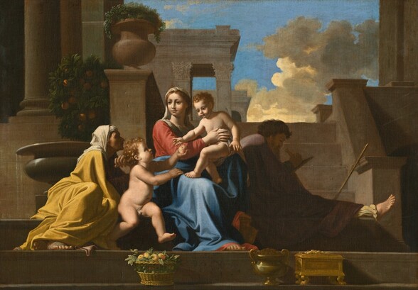 We look up at two women, two young boys, and a man, all with pale skin, sitting together on a wide landing, with stairs leading up to stone buildings behind the group and a patch of vivid blue sky in the upper right corner of this horizontal painting. At the center, a woman, Mary, sits holding a nearly nude child propped on one knee. Her body is angled to our right but she turns her head to look off into the distance to our left with large, dark eyes under faint brows. Her strawberry-blond hair is pulled back under a white veil that falls down the back of her neck and across her chest. Her smooth cheeks are lightly flushed in her round face. She has a straight nose and her pink, bow lips are closed. She wears a coral-red dress under a long, azure-blue robe that wraps around her waist and covers her legs. The sandaled toes of one foot peek from under the hems, and her other foot rests up on a gold-colored, rounded urn. Mary holds one child on her lap, and the second child sits by her right side, to our left. Both toddlers have blond, curly hair, dark eyes, rounded faces, and slightly pudgy bodies. Swaths of pale gray drapery mostly cover the genitals of both. The child on her lap half-sits, half-stands on the knee propped up on the urn. She supports his belly with one hand, the other wraps around his bottom. He leans forward, toward the second child, who faces him and holds up a yellow and blush-red fruit. Behind him, to our left, an older woman sits leaning forward and facing Mary in profile. Her wrinkled face is mostly lost in shadow, and she has a hooked nose and her forehead is lined, as if her eyebrows are raised. A white veil is wrapped around her head and drapes over the shoulders of her long, canary-yellow dress. One foot is crossed behind the other ankle, and the toes of both peep out from under her dress. To our right of Mary, a bearded man, Joseph, wears an eggplant-purple robe and sits almost entirely in shadow, facing our right in profile. The leg closer to us is extended and his foot stretches out of the shadow. He has short, curly brown hair and a long gray beard. He holds a carpenter’s compass to a panel in front of him. Closest to us, a step down runs along the bottom edge of the painting. On that step, a basket with leaves and yellow and peach-colored fruit sits in front of the standing child. Near Mary’s feet is a bronze-colored urn and a shiny gold box on raised feet. Behind the older woman to our left, water trickles from a round-bellied fountain on a pedestal in front of an orange tree. One building with round columns rises behind the tree. Behind Joseph, a long stick rests against the post of a short flight of four steps, which leads to another landing. The portico of a second temple-like building with squared columns and leafy capitals rises over Mary, presumably from the upper landing. A bright, topaz-blue sky with cream-white and steel-gray clouds fills the upper right corner of the composition.