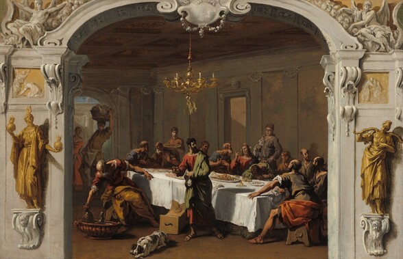 Seen through a wide, shallow, ornamental, stone arch, seventeen light-skinned people and a dog gather around or near a long banquet table set with plates of food in this horizontal painting. The table angles away from us so the short, right side is closest to us in the darkened room, which is lined along the far wall with shallow columns and capitals. To our left, an arched doorway in the room opens to a view of a stone structure and a sliver of blue sky. A gleaming, gold candelabra with curving arms hangs over the table from a coffered, possibly wooden ceiling. The table is covered with a white cloth. Men crowd around the short ends and the long side of the table opposite us. In pairs and trios, the men converse or look toward a man with light radiating from the top and sides of his head, at the center of the far side of the table. That bearded man, Jesus, has long brown hair and points his index finger upward with his right hand, on our left. The other men at the table wear robes and tunics in sage green, tan, brown, or slate blue. A portly man behind Jesus stands with a cloth draped over one forearm and his other hand on his hip, looking down at the table. Another cleanshaven man stands holding a large platter at the far corner of the table, and two people, perhaps a man and woman, appear to be walking away from the table but look back over their shoulders to our left. On the long side of the table, closer to us, a man to our left, balding with a long gray beard, sits on a narrow, bench-like seat and twists to pick up a jug from a large basin on the floor. The final man stands near an overturned seat as he turns his back on the table. He gestures forward, to our left, with one hand as he looks back over his other shoulder. A white dog with brown spots chews on a bone near the overturned seat. The highly decorated wide archway through which we see the scene seems to be carved from pale, fog-gray stone with scrolling moldings and capitals. The arch has a shield-like decoration at the top center, and is flanked by sculpted people in the upper corners. Two larger golden statues of robed women stand on floating plinths to either side of the arch. The woman to our left holds flaming orbs and the other holds a yoke across her shoulders. Though the painting seems rather illusionistic from afar, closer examination shows that it is sketchily painted throughout.