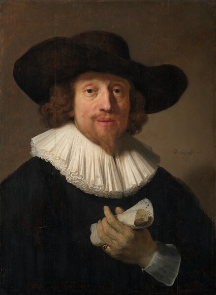 Shown from the waist up, a bearded man with pale, peachy skin, wearing a black wide-brimmed hat and jacket, and a broad, layered, white collar, holds up a piece of rolled up paper in this vertical portrait painting. His shoulders are angled to our right but he turns his face to look at us with dark gray eyes. He has a bumped nose, and his full pink lips are slightly parted. There are bags under his heavy-lidded eyes. A light brown mole marks his soft cheek, on our left, and there are jowls along his jawline. His honey-brown goatee is trimmed to a point, and his brown curly hair falls to his collar. The wide brim of the hat sweeps down a bit to our right. Layers of white fabric create a wide collar that rests against his chest and nearly reaches his shoulders. His dark coat is a field of black, broken only by the sheer white cuff and the hand he holds up in front of his chest. The skin of that hand, his left, has a greenish cast, and he wears a gold ring on the pinky finger. Musical notation is visible on the rolled-up paper he holds loosely in that hand. He is lit from our upper left so casts a shadow against the peanut-brown wall behind him. The artist signed and dated the painting near the man’s shoulder, to our right: “Rembrandt f 1633.”