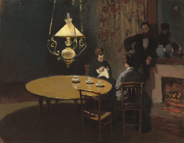 In a darkened room, two women sit at a round table near a man who stands leaning against a fireplace mantle, all illuminated only by a soft, yellow light from a ceiling lamp hanging over the table in this nearly square painting. All the people are light skinned and have brown or dark hair. The brushwork throughout is loose and details are indistinct. The brightest object in the room, the light, has a flaring shade over a spherical body, and hangs from three curling, scrolling arms. Painted in butter and golden yellow, it seems to be made from brass. The table is bare except for a white teapot and two small, white teacups on saucers near the women who sit to our right. The women have turned their wooden chairs to face each other next to the table, so the one closer to us sits with her back to us. Both have brown hair pulled up in buns, and they look down at their hands. The woman farther away wears a pine-green dress with white trim at the cuffs, and the one facing away from us wears a slate-blue, high-necked dress with a white collar. The one who faces us wears holds something white in her hands, presumably needlework. A third chair at the table, closest to us, is turned toward the women, but is empty. The man stands in semi-darkness behind the two women next to a glowing fireplace. He has a full beard and wears a black suit. He leans on the mantel with his left arm, on our right, with his other hand on his hip. Though his eyes are deeply shaded, he seems to look down at the woman in the blue-gray dress. A large mirror over the fireplace reflects the heads of the man and the woman facing us, as well as the back of a blue-gray lidded vase on the mantel and a clock hanging on the opposite wall, out of our view. A curtain runs along the wall beyond the fireplace and is painted with the suggestion of a floral pattern in strokes of forest green, burnt orange, gray, and tan. The rest of the room is swallowed in shadowy areas of dusky browns, grays, and tans. The artist signed the work in red letters in the lower left corner: “Claude Monet.”