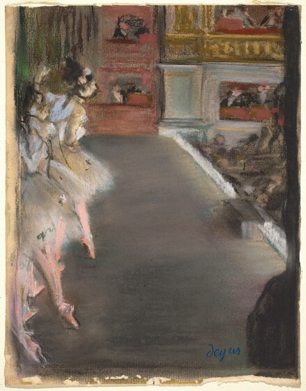 We look slightly down and across a stage, as if from the wings, at a ballet performance with ballerinas to our left and the audience to our right in this vertical print. The artist has added strokes in pastel in some areas, as for the dancers’ pink tights and pointed toe shoes. The whole scene is loosely rendered, either with pastel or in the monotype print on which the artist drew. There are at least three ballerinas lined up in a row moving away from us, along the left edge of the paper. Their dark hair is pulled up and, for the woman farthest from us, two pink flowers adorn her hair. They wear costumes with silvery-white bodices and flaring, knee-length tutus. An area streaked with pine green and brown in the upper left corner could be a curtain behind the dancers, and people wearing black watch from red box seats across the stage from us. The surface of the stage itself is a blend of charcoal gray and rose pink, and the edge is lined with white to our right. The audience is a made up of a few peach dots within strokes and smudges of black. More gold and brick-red box seats fill the wall opposite us. There is a black silhouette along the right edge of the paper, with a bulge near the bottom right corner perhaps indicating the shoulder of an onlooker from the wings, next to us. The artist signed the work with vibrant blue near the lower right corner, “degas.”