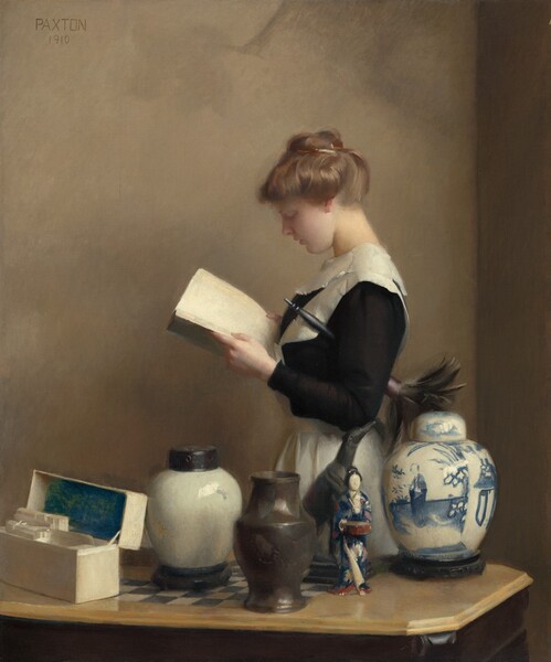 A fair complexioned young woman dressed in a black and white servant’s uniform stands reading a book behind a collection of urns, a figurine, and a stationary box arrayed on a tabletop in this vertical painting. Seen from about the hips up, the woman faces our left in profile as she gazes down at the open book in her hands. She has a turned up nose, smooth skin, and her lips are slightly parted over a rounded chin. Her blond hair is pulled up in a bun and she wears a black dress with a wide, white collar and a white apron tied around her waist. A feather duster with a black handle is tucked under her left arm, closer to us, so the dark feathers fan out behind her. She stands in the corner of a room with light tan walls. Between us and the woman and running parallel to the bottom edge of the canvas, a wooden gaming table inlaid with a black and white checkerboard pattern on its top holds five objects. To our left, the hinged lid of a white rectangular box has been opened to reveal ivory colored note cards and envelopes. The inside of the box lid is painted cobalt blue. Next to the box is a white ceramic jar with a rounded body and a flat, dark lid. At the middle of the table and a little closer to us, a brown vase with a tall, inward curving neck sits next to a figurine of a person wearing a blue and pink kimono. Lastly, a white lidded jar painted in blue with a person and landscape sits to our right. The artist signed and dated the painting in dark, capital letters near the upper left corner: “PAXTON” and “1910.”