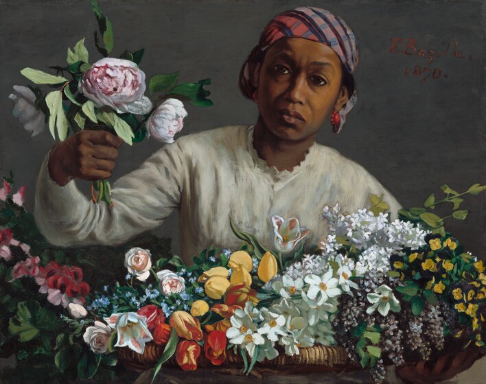 Holding a bunch of peonies in one hand, a woman with brown skin leans forward, toward us from behind a large basket holding dozens of flowers in this horizontal painting. The basket holding the flowers spans the width of the canvas, and the woman is shown behind it from the chest up. She wears a cream-white, long-sleeved blouse with scalloped trim around the high neck. She wears coral-red earrings, and a plaid cloth in tones of rust red, slate blue, pale purple, and black is tied tightly over her black hair, which is visible over her ears. Her brow is slightly furrowed, and she looks at us with large, dark eyes. Her full mouth is closed, the corners faintly downturned. She reaches her right arm, on our left, toward us with a bouquet of three pink-and-white peonies and greenery. Her basket is filled with yellow and red tulips, pink roses, white and purple lilac, and other white, pink, yellow, and blue flowers, and it takes up the bottom third of the composition. The woman and basket are shown against a dove-gray background. The artist prominently signed and dated the work with red letters near the upper right corner, near the woman’s head: “F. Bazille. 1870.”