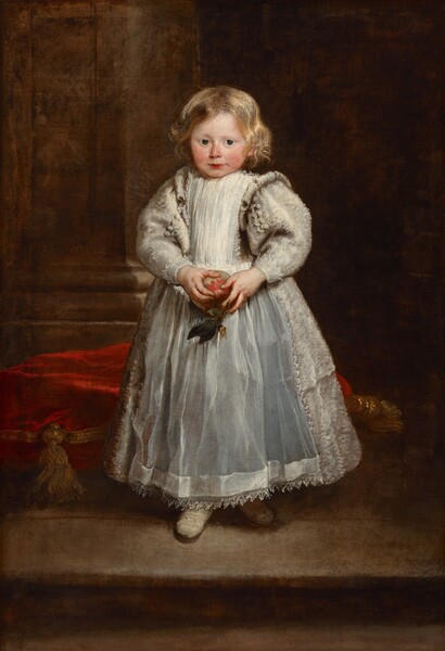 A young girl with light skin, round, rosy cheeks, and blond hair holds an apple and wears a full, ankle-length, silvery white dress with puffy sleeves in this vertical portrait painting. She stands with her body slightly angled to our left, and she turns her face to look at us with large, dark blue eyes under faint brows. Her wavy blond hair falls to her chin and glimmers where it catches the light. Her nose and cheeks are flushed, and her rose-red lips are closed. She holds a red and green apple with both hands at her waist. Her dress has a high neck and voluminous, puffy sleeves with lace at the cuffs. Her dress is covered by a smock down the front and an apron over the full skirt. The apron is edged with lace and seems to be smooth, which contrasts with the textured appearance of the skirt and sleeves. The rounded toes of her cream-white shoes poke out under the ankle-length hem of her dress. She stands on a platform or on a step, and a crimson-red cushion with gold trim and tassels rests on the floor behind her. To our left, a thick, square column rises from a tall base and reaches off the top edge of the composition. The background to our right is dark with shadow.