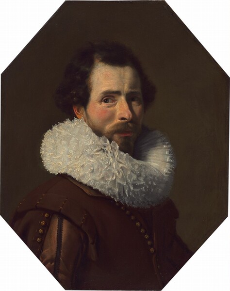 Shown from the chest up, a bearded man with pale skin and flushed cheeks wears a chestnut-brown jacket with a thick, lace-trimmed, pleated, cream-white collar in this octagonal portrait painting. The man’s body is angled to our right, and he cuts his light brown eyes back to look at us. Wrinkles line the corners of his eyes under dark brows, and he has a straight, narrow nose and high cheekbones. His red lips are closed and almost lost in the shadow of his full, trimmed beard. His dark brown hair is combed back from a receding hairline and falls around his ears. The dense, ruffled collar comes up to the earlobe we can see. His brown vest has a row of gold buttons down the front, and there are more gold buttons down the sleeve. He is lit from our left so the far side of his face is in shadow. The dark brown background lightens slightly around his face.