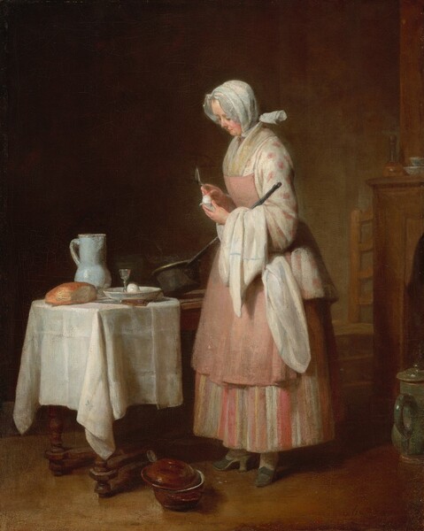 A fair-skinned woman stands holding a long-handled pan and egg in front of a wooden table near a fireplace mantle in this vertical painting. The scene is brightly lit from our left, and the background falls into shadow. To the right of center, the woman wears a hip-length, ivory-white jacket patterned with large, rose-pink dots over a long skirt with vertical stripes of peach, shell and bubble gum pink, white, and tawny brown. A knee-length, petal-pink apron is pinned to the front of her dress. A frilled white bonnet covers her hair, and she wears fern-green, high-heeled, slip-on shoes. Her body faces our left almost in profile. She holds a silver spoon in her right hand as she peels the egg she holds in the other. A white cloth with a powder-blue stripe is draped over her left arm, which is bent to cradle the long handle of an iron-grey pot. She stands in front of the table, which angles away from us. The end of the table closest to us is covered with a creamy white cloth under a golden, round loaf of bread, a tall sky-blue pitcher, a shallow bowl with another egg and a pewter egg cup inside, and a large knife with a wooden handle. A mahogany-red pot with its cover askew sits at her feet. Behind the woman and to our right, the mantle and fireplace is cut off by the right edge of the canvas. A wooden ladderback chair peeks out from beyond the mantle, and a tall, covered, olive-green pitcher sits on the floor in front of it. A stoppered flagon and two bowls sit on the corner of the mantle. The wall and floor are fawn brown, darkening in shadow toward the back and left of the room.
