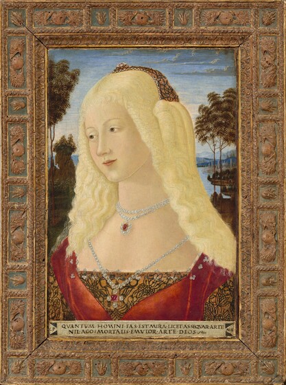 Shown from the chest up, a light-skinned, blond young woman wearing a gold and red gown and pearls looks off to our left in this vertical portrait painting. Her face and body both angle to our left, and she gazes in that direction with brown eyes under faint brows. She has smooth skin, a long, straight nose, and her closed, light pink lips curl up slightly at the corners. Long, cottony, light blond hair falls over her ears and flows down beyond her shoulders. At the back of her head, she wears a caramel-brown cap decorated with black, web-like lines and a row of pearls along the front edge. Her bodice is the same golden brown color, with the black linework in a leaf and floral pattern. The low neckline runs straight across her chest, and swaths of scarlet-red fabric wrap over her shoulders to meet in a wide V. Clusters of three tiny pearls line the squared edge of her neckline. A double-stranded pearl necklace has a red gemstone pendant that hangs at the base of her neck. A third, single strand of pearls hangs low over her chest, holding a pendant with a magenta-pink stone flanked by more pearls. A landscape stretches into the distance behind her. Dark green, grassy fields dotted with trees leads back to a winding body of water, over her shoulder to our right. Stone walls enclose at least two clusters of buildings, including several towers, far back along the banks. The light blue sky is tinged with petal pink near the horizon, over mountains painted blue in the hazy distance. An ivory-white band spans the bottom edge of the portrait, and is inscribed, “QVANTVM HOMINI FAS EST MIRA LICET ASSEQVAR ARTE. NIL AGO: MORTALIS EMVLOR ARTE DEOS.” The band is flanked by a triangle to each side; the one to our left has the letters “CP” or “OP,” and the one to our right reads “NER” with the N and E conjoined. The painting has an ornately carved, brown wooden frame. A rope design divides the border into alternating squares and rectangles. Each rectangular box has a pair of carved eagle heads flanking an orb, while a flame-like shape is in each of the smaller square boxes. The boxes and trim have slate-blue backgrounds, and gold edging.