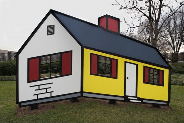 This free-standing sculpture is made up of panels and geometric shapes of vivid yellow, crimson red, white, and slate gray, all outlined with bold, jet-black lines, to create a simplified, cartoon-like, single-story house. The sculpture sits slightly off the ground on four metal feet, and is displayed on a grassy lawn with an iron fence and trees in the background. One short end of the house faces us, to our left. The peaked wall is white and is pierced with a window divided into six empty panes, two across and three down, and flanked by red shutters. Above the window is a tall, rectangular air vent with six horizontal slats. Below the window a loose grid of three horizontal lines and four short, vertical lines suggest an abstracted brick pattern. The long side of the house moves away from us to our right. It has a red chimney at the center of the gray roof. The wall of the front of the house is canary yellow. There is a white door at the middle and two more six-paned windows with red shutters to each side. Two shallow white steps leading down from the door are suggested by staggered, narrow rectangles. A dove-gray band runs along the bottom of both walls. All of the features, including the windows, shutters, door, chimney, roof, and gray band are outlined in black.