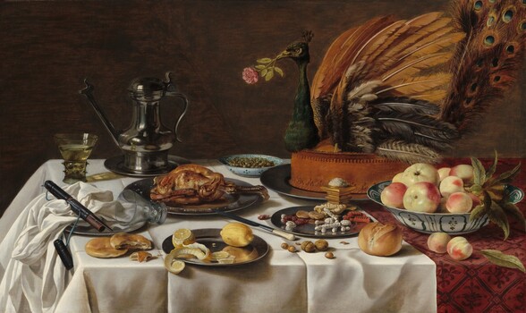 On a tabletop spread with an ivory-white cloth, plates, and white porcelain bowls containing sweets, fruit, olives, and a cooked fowl are arranged around the largest platter, which holds the head, wings, and tail of a peacock stuck into a tall, baked pie, in this horizontal still life painting. The front, left corner of the table is near the lower left corner of the painting, so the tabletop extends off the right side of the composition. The white tablecloth lies over a second cloth underneath, which is only visible along the right edge. The cloth underneath has a leafy, geometric pattern in burgundy red against a lighter, rose-red background. The peacock pie is set near the back of the table, to our right, so it fills the upper right quadrant of the composition. The bird holds a pink rose in its beak. In front of it, near the lower right corner of the painting, a white porcelain bowl painted with teal-green floral and geometric designs holds about ten pieces of pale yellow and blush-red fruit. A pewter plate next to it, to our left, holds dried fruit and baked, stick-like sweets, some covered with white sugar. A pile of salt sits atop a gold, square vessel between the sweets and the peacock pie. Another blue-patterned, white porcelain bowl filled with green olives sits near the back of the table next to a lidded, pewter pitcher with a long spout. Other pewter plates hold a baked fowl, like a small chicken, and, closest to us, a partially cut lemon with its peel curling off the plate. Nuts, more fruit, an ivory-handled knife, bread rolls, and flat biscuits sit on the white cloth among the plates. One glass with a wide stem covered in nubs and a flaring bowl sits near the back, left corner of the table, filled with a pale yellow liquid. An empty glass lies with the upper rim on another pewter plate, to our left. Also on the plate is a bunched up white napkin and a leather case for the knife. The background behind the still life is brown.