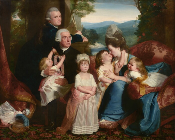 A group of three adults and four children are gathered on and around a couch in an interior space that opens out to a distant hilly landscape in this horizontal portrait painting. All seven people have pale skin and are clustered across the middle of the composition. To our left, an older man wearing a white wig, white cravat, and black jacket sits facing us as he holds a squirming baby on his lap. The man’s slightly tanned face is turned to gaze to our right with pale blue eyes under thick brown eyebrows. Jowls line his jaw around pursed lips. The child in his lap twists to look up at him. She holds up her pudgy arms, grasping a gold-colored rattle with bells in her left hand. She has blond hair, smooth skin, and rose-red lips, and she wears a long white gown with a petal-pink sash around the waist. Behind this pair a younger man stands with his body angled to our right in profile as he turns his face to look at us from the corners of his eyes, with a faint smile on his closed pink lips. He also wears a white cravat and black jacket, but his hair is dove gray. His forearms rest on a low, olive-green stone column in front of him, his hands crossed at the wrist as he holds papers in his right hand. To our right and at the center of the group, a young girl stands facing us with her arms crossed at her waist. A lacy, ivory cap frames tawny brown bangs that sweep across her forehead. Her petite nose, brown eyes, and rose-red lips are set within her round face. She wears an ivory-white gown belted with a sash that shimmers from pink to copper as it cascades down her right side, to our left. On her other side, the final trio includes a woman sitting with her arms entwined around two more small children. They sit on a cranberry-red, brocaded sofa. Her sapphire-blue gown has a voluminous skirt and is trimmed with gold stitching along its square neckline. The fabric gleams softly, suggesting silk. Her dark brown hair is piled high on her head, topped by a sheer white veil. Her body is angled toward us, but her head is turned in profile to our left, bowing to almost brush noses with the young child standing alongside her. Shoulder-length brown hair falls to the child’s shoulders as the head is tipped back to gaze at the woman with a wide smile. One arm reaches up and embraces the woman’s neck and the other rests on her knee. The child wears a butter-yellow gown with a white sash around the waist. The fourth and final child lies belly down across the red and copper bolster cushion of the couch so her elbows are propped on her mother’s lap. The child turns her head back to look at us with dark eyes and slight smile on her pale pink lips. Her blond hair falls down the back of her white gown, which is belted with a gold sash. A child’s doll and hat with a rounded crown, a narrow brim, and an indigo-blue feather rests in folds of the curtain on the floral-patterned carpet near the lower left corner of the painting. The scene is framed by rust-red drapery edged in gold hanging from the upper left. In the landscape seen through an opening behind the family, hills fade from sage green to slate blue, and they become more faint as they recede to the horizon, which comes about three-quarters of the way up this composition. The opening is framed with a flowering vine climbing the wall behind the woman.