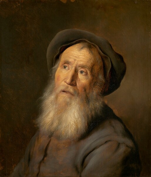 Shown from the shoulders up, a bearded man with wrinkles lining his pale-skinned face looks up and to our left, toward a bright light source, in this vertical portrait painting. His shoulders are angled to our left, and he tips his head slightly back so his face turns toward us. He looks up from the corners of his gray eyes under bushy brows. A soft gray cap, pushed back high over the crown of his head, frames his face over a few tuffs of charcoal-gray hair on his high forehead. His brows are furrowed and his hollow cheeks ruddy. He has a silvery gray mustache, and his long, full beard falls to his chest. Lines have been incised in the gray and white paint of his beard to reveal an underlayer of rust orange. His slate-gray tunic is streaked with fawn brown to create highlights. The background is painted with blended strokes of leather brown and touches of golden orange, and it lightens around the man’s head.
