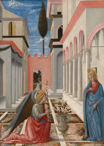 On a tiled courtyard between buildings with arches and columns, a winged angel kneels and looks up at a woman standing to our right in this vertical painting. Both people have pale skin, blond hair, and plate-like gold halos at the back of their heads. To our left, the angel wears a silvery-white tunic under a scarlet-red cloak lined with cobalt blue. The wings are fawn brown on the underside, closer to the body, and aquamarine blue on the outside. Gold lines delineate feathers. The angel holds a white lily with two blooms and four buds on a long stem in the hand farther from us, which rests on a bent knee. The other hand is raised in front of the chest. The woman, Mary, stands along the right edge of the painting, her body angled toward the angel. Mary’s long, wavy hair falls to her shoulders, and she wears a lapis-blue robe with a pine-green lining over a red dress. She holds her right hand, farther from us, to her chest and touches the fabric of her cloak with the other, by her hip. The tip of one red shoe peeks out under her voluminous robe. Between the angel and Mary is a stone-white urn with scrolled handles, holding a bouquet of pink and white roses with dark green foliage. The ground is tiled with squares marbled in pale pink, sky blue, rust red, charcoal gray, and brown. Narrow, white panels between the tiles create a grid. The buildings around the pair are fog gray, parchment white, shell pink, or coral red, and are trimmed in black, red, or pink. Rows of arches recede into the square behind the angel and woman, ending at a coral-red wall that encloses the courtyard. An arched doorway in that wall opens onto a pathway leading over a small brook and into a hilly forest. A narrow, conical tree outside the courtyard reaches over the wall, into the vibrant blue sky above. A white dove descends from among the few scattered clouds with golden beams projecting toward the woman to our right.