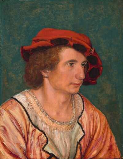 Shown from the chest up, a cleanshaven man with peachy skin sits angled to our right in this vertical portrait painting. He has chin-length, curly, auburn-red hair. He gazes off to our right with hazel eyes under thick brows. He has a slightly humped nose, and his wide mouth is closed. Loose jowls line his jawline. A large, soft, scarlet-red cap covers the top of his head and hangs down over the far ear, to our right. The brim is upturned and the underside lined with brown ovals. He wears a salmon-pink tunic over an apricot-colored undergarment, which is striped with thin gray strokes. The loose neckline of the tunic is trimmed with black. A background is streaked with emerald green and tan.