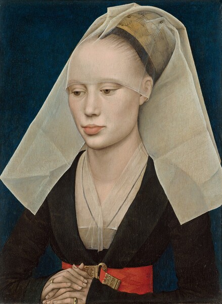A woman with pale white skin and blonde hair is shown from the waist up in this vertical portrait. Her folded hands rest on the lower edge of the panel, suggesting that she sits just on the other side, close to us. A transparent white veil covers her blonde hair and falls in stiff, wide panes down in front of her shoulders. Her hair is pulled back behind a black ribbon over a high forehead. Her light brown eyes are downcast and she has a straight nose and full, pale pink lips. Her chest is covered by another veil and is tucked into the deep V-neck of her long-sleeved, black dress. A wide scarlet belt adorned with an ornately filigreed gold belt buckle encircles her narrow waist. Her porcelain skin, white veils, and red belt contrast sharply with her velvety black dress and the dark pine green of the background.