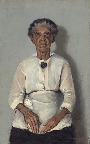 In this vertical portrait, an elderly woman with brown skin, wearing a blouse, apron, and skirt is painted with a limited palette of grays, browns, black, and whites. Her head, torso, and lap nearly fill the composition. She is shown straight-backed against a neutral gray background, facing and looking at us with her hands resting in her lap. Her wavy, iron-gray hair is parted in the center and pulled back from her face. Her eyebrows are slightly raised and her face is deeply lined down her cheeks and around her mouth. She wears a heart-shaped brooch with a red stone at its center at her neck and a gold band on her left ring finger. The light coming from our left casts a shadow against the wall to our right. The artist signed and dated the painting in the lower right corner: “A.J. MOTLEY. JR. 1922.”