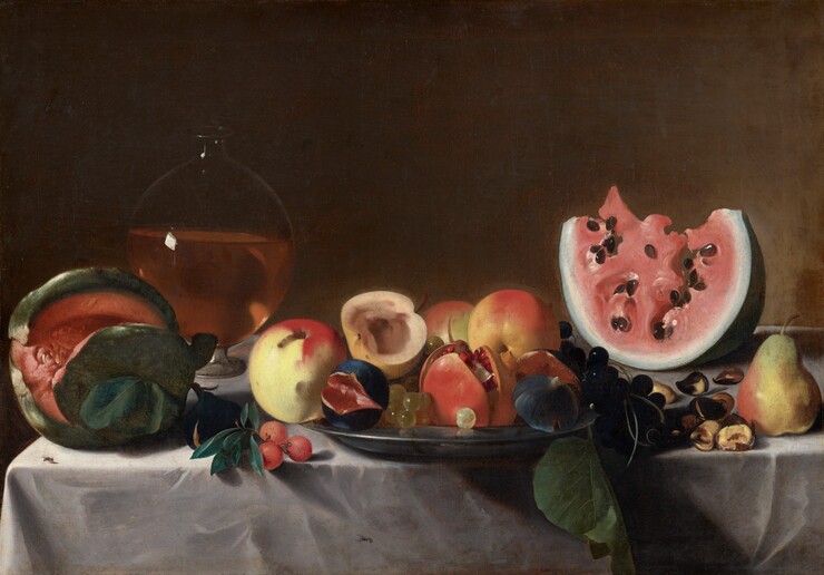 Melons, apples, pears, and other fruits, along with a glass vessel and chestnuts, are arranged along a tabletop covered by a white cloth in this horizontal still life painting. The left edge of the table is close to that edge of the canvas, and the table extends off the right edge. Starting at the left, the melon near the edge of the table has a forest-green rind with coral-colored flesh. Just behind it, to our right, the spherical glass vessel is about half filled with amber liquid. Next to the melon and in front of the vessel is a dark-skinned fig and a cluster of three red berries. At the center of the composition, a pewter plate holds three yellow and red apples and a fourth piece of fruit, perhaps a pear or apple, cut in half. There are also several green grapes, a pomegranate split open to expose the ruby-red seeds, and two more black-skinned figs cut so the rose-pink flesh shows. A bunch of dark purple grapes and a green leaf spill out of the right side onto the table. A wedge of pink watermelon with black seeds sits on the far right toward the back of the table. A yellow and pink pear stands near the front of the table to our right, and a handful of chestnuts is scattered between the pear and watermelon. Two tiny insects, like small flies, sit on the tablecloth, one near the melon to our left and the other on the front of the tablecloth near the lower center. Bright light from the upper left glints off the carafe, the edge of the plate, and the seeds of the pomegranate and watermelon, and it creates deep shadows around the fruit. The background lightens from earth brown along the top to sable brown near the table to our right.