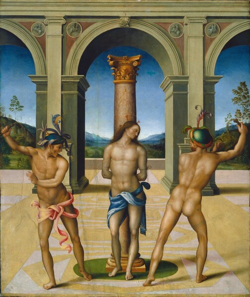 Two muscular men lean away, whips raised, from a third man tied to a freestanding column, in a courtyard-like space in front of a deep landscape in this vertical painting. At the center of the composition, the pale-skinned man bound to the column, Jesus, stands with his body facing us. He turns his head to our right, perhaps looking at the man to that side. Jesus is cleanshaven, and his long brown hair falls back behind his shoulders. A delicate gold ring creates a halo, with red spokes to the top and sides. Ropes wrap around his upper arms, and he is nude except for a blue cloth around his hips. The column is mottled with tan and pale pink, and is topped with a gold, leafy capital. To each side, the men with the whips have more tan skin than Jesus. They stand in the same pose as each other, with their weight mostly in their right legs, and right hands raised with the whips. But the man to our left stands with his body facing us, and the one to our right stands with his back to us, so they each lean away from Jesus. The man to our left wears a pink cloth tied around his waist but is otherwise nude. His mouth is wide open, and his free hand reaches across his chest. His royal-blue cap is decorated with lavender-purple and gold ribbons and plumes. The man to our right is nude except for a parrot-green cap wrapped with a band of orange, like a turban. The area in which they stand has a floor patterned with butter yellow and white. On the far side of the courtyard, a central arch is flanked by one to each side, which are cut off by the left and right edges of the composition. The entablature running across the top of the arches is parallel to the top edge of the painting. The landscape beyond has grassy, rolling hills dotted with trees, reaching back to hazy blue mountains along the horizon. The sky above deepens from pale blue over the mountains to azure blue across the top, seen through the arches. Several vertical cracks are visible on the surface of the panel.