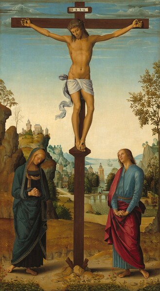A man hangs from a wooden cross at the top center of this vertical painting, with a woman standing at the foot of the cross to our left and a man to our right, all in front of a deep landscape with a town and mountains along a river. All the people have light skin. The feet of the man on the cross, Jesus, line up with the tops of the heads of the people standing below. Jesus hangs by a nail driven through each palm, and his overlapping feet are nailed into a short platform that angles downwards. He has shoulder-length brown hair and a short brown beard. His head tips forward and his eyes are downcast or closed. He has a straight nose, high cheekbones, and his lips are closed. Blood trickles down his forehead from a ring of thorns around his head, from the nails in his hands and feet, and from a short gash over his right ribs, on our left. A white loincloth is wrapped around his hips and the end of it flutters as if in a breeze to our left. The man’s body is lean but muscular. A slip of paper with the letters “INRI” has been affixed to a small panel on the cross above Jesus’s head. Below and to our left of the cross, a woman stands with her head bowed, looking down at the ground with her hands clasped in prayer. Her hair is covered with a tan-colored veil and she wears a gold-edged, navy blue robe that covers her head and body. She and the clean-shaven, blond man standing to our right of the cross both have bare feet. The man looks up at the cross with his lips parted. His fingers are intertwined and then flipped, palms-down, with his arms straight. His raspberry pink robe falls over one shoulder and around his hips, over a topaz-blue, ankle-length tunic. The dirt-packed ground on which they stand is lined along the bottom edge of the panel with plants and flowers. The golden-brown land dips beyond the people, leading down to a river that winds into the distance. A castle-like structure perches on cliff-like outcroppings high along the left edge of the painting and buildings at the foot of that outcropping line the river. Two people walk and one person fishes off a bridge near the town. A few boats, one with full sails unfurled and another possibly with oars out to row, float in the river beyond, which is flanked in the deep distance by mountains painted blue in the haze. The horizon comes about halfway up the composition, crossing the painting just beneath Jesus’s feet. The sky above deepens from pale yellow along the horizon to robin’s egg blue where a few wispy clouds create streaks along the top edge.