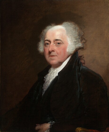 Shown from the waist up, a pale-skinned, clean-shaven man sits looking at us in front of a peanut-brown background in this vertical portrait painting. His shoulders are angled to our left, but he turns his head to look at us with blue eyes under dark, arched brows. He has a bumped nose, fleshy, flushed cheeks, loose jowls, and a round chin. He has bags under his eyes, crow’s feet, and his thin pink lips are parted. Gray hair curls like bushes to each side of his balding head, which is white across the top of his pate and down the long, bushy sideburns. He wears a high-collared white shirt with a ruffle at the throat under a similarly high-collared black coat. His left elbow, to our right and closer to us, rests on the arm of a wooden armchair. That hand rests in a loose fist in front of the man’s waist, and the cuff is lined with white lace.
