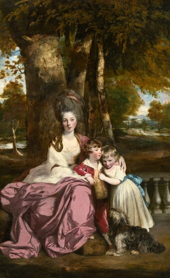 An elegantly dressed young woman, a little boy, girl, and a dog are gathered on a veranda in front of a sun-dappled landscape in this vertical portrait painting. All three people have pale skin with rosy cheeks. To our left, the woman sits facing us in front of a low, pewter-gray balustrade. She loosely embraces both children who lean onto her lap, to our right, as the shaggy, dark gray dog looks on. The woman has a slender, oval face, a long nose, rose-red lips, and hazel eyes that gaze just beyond our right shoulder. She wears a diaphanous, parchment-white gown belted at the waist and cinched at the elbow. Over the gown, a voluminous, dusty rose-pink mantle drapes over one shoulder and wraps around her hips and legs. Her dark gray hair is piled high on her head, and loosely painted strokes of garnet red suggest a scarf wrapped around the top. One long tendril loops over one shoulder. The boy closest to the woman rests his elbow along her lap so his body turns slightly away from her. His round face is framed by chestnut-brown curls and bangs, and he looks off to our right with blue eyes. He wears a cranberry-red jacket and breeches, with a gold and yellow striped vest. The wide collar of his white shirt is spread open, and one frilled cuff extends from the sleeve we can see. The woman holds the hand resting on her lap, and both she and the boy wrap their other arms around the little girl. The boy’s small fingers are tucked in at the back of the girl’s neck, just under the woman’s hand. The girl’s body turns as she leans into the boy, reaching one hand to grip his vest. Honey-blond curls frame her round face. She ducks her head as she looks to our right, a smile on her lips. She wears a cream-white gown belted with a celestial-blue sash. Facing away from us, the small dog sits and looks up at the trio. It has shaggy, charcoal-gray, tawny-brown, and white fur. Beyond the balustrade, tall trees covered in pine-green, gold, and brown leaves spread out on either side and recede toward hazy, lilac-purple mountains in the far distance.