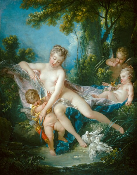 A nude woman and three small, winged children gather among bushes and lush vegetation at the edge of a clear pool in this vertical painting. All four have pale skin and blond hair. The children are pudgy with baby-like proportions and have short gray and blue wings. The woman half reclines on swaths of white, pale pink, and peacock-blue fabric draped across the bushes or the ground. She leans her torso to our left and leans toward that elbow, which is propped up on the fabric. The toes of her right foot, on our left, brush the ground near the water, and her other leg is angled to continue the diagonal created by her elbow and torso. Two white doves nestle by her lower foot. Her ash-blond hair is bound up with pearls, and she has rosy cheeks, pink bow lips, and smooth skin. She reaches across her body and down to our left to touch a nearly nude young boy. He wears a butter-yellow garment pulled up around his chest, perhaps by the woman. A quiver of arrows hangs from a blue ribbon at his side, and he raises his hands before him, toward the woman's arm. To our right, one of the other children reclines on the pink and blue drapery and faces the woman in profile. The third child leans forward from the bushes behind the reclining child. The bushes and trees of the lush forest around the figures creates a V-shape with the people at the center. Vibrant blue sky fills the upper left quarter of the painting.