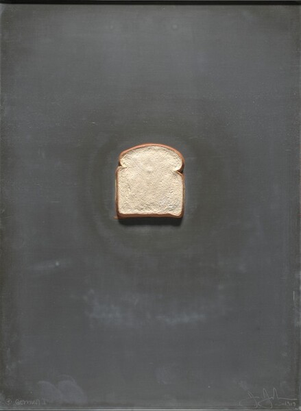 A piece of white bread sits against a charcoal-gray, vertical, rectangular field. The piece is cast in lead, and the bread painted. Incised in the lower left corner, an inscription reads, “Gemini I.” To the right, a second incised inscription reads “J Johns 1969.”