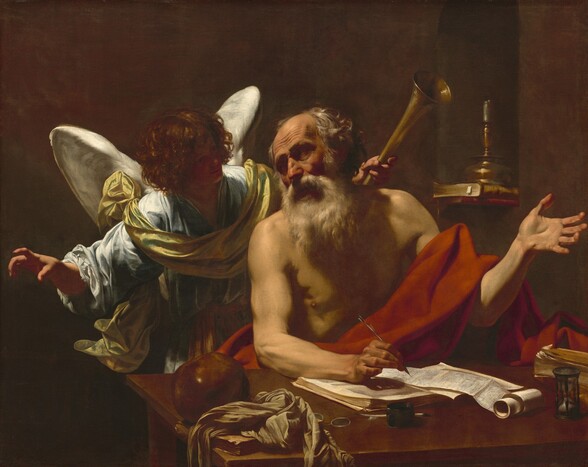 Shown from the waist up, an elderly, balding, light-skinned man with a bushy white beard sits behind a table, facing us, in front of a winged angel who looks on in this shadowy, horizontal painting. The man sits with his body angled slightly to our right, and he turns his head to look in the opposite direction. His eyes are sunk in shadow under deeply furrowed brows, set in his lined face. His sparse, gray and white hair is tousled. He wears only a scarlet-red cloth draped across his lap and over his sinewy left arm, on our right. His open left hand is raised, palm up, at shoulder height. In his other hand, he holds a pen, hovering over a partially unwound scroll. His forearm rests on an open book beneath the scroll. He looks over his right shoulder at the curly-haired angel with snow-white wings. The angel wears a flowing, light blue robe with a golden yellow cloth draped around the chest and over the shoulders. Softly smiling, the backlit angel leans toward the man, face deep in shadow. With arms lifted, one hand gestures with a slightly crooked finger, pointing beyond the picture’s border to our left. In the other hand, the angel holds a golden horn in the dusky background behind the man’s left shoulder. Behind the man and angel and to our right, a single candle sits on two books lying in an arched wall niche. On the desk closest to us are a crumpled cloth on a book, a shiny rust-brown ball, a pair of eyeglasses, an inkpot, an hourglass, and a second book, to our right. Light coming from our upper left starkly illuminates the two people against the shadowed, earth-brown background.
