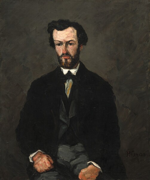 A light-skinned man with thick black hair and a squared off black beard, dressed in a black jacket over a gray vest and gray trousers, sits facing us in this vertical portrait painting. This work is loosely painted with visible brushstrokes so some details are difficult to make out. The man's body faces us but he looks down and to our left. The tip of his nose almost matches the coral red of his lips. Two pale peach patches below his mouth break up his beard on his pointed chin. His hands, closed into fists, rest on his thighs, which are cropped by the bottom of the canvas. He wears several layers of clothing. The open black jacket reveals a charcoal-gray vest with a V-shaped opening over another black garment, perhaps an undervest. This is worn over a white shirt, which is visible as bright traingles at this throat and white cuffs at his wrists. The white shirt seems to be tied with a black tie and possibly a gray cravat, but this area is broadly painted. The background is painted with gray strokes over black. The artist signed the painting in black paint in the lower right corner, though it is barely visible: “P. Cezanne.”