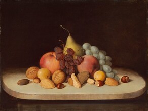 Several pieces of fruit, bunches of grapes and raisins, and several types of nuts in their shells are piled in a pyramidal form on a round, cream-colored, possibly wood tabletop against a dark background in this horizontal still life painting. The food is brightly lit from the front, and the tabletop seems to tip slightly down. There are two round red apples and two pieces of small yellow fruit, perhaps quinces, flanking a golden yellow pear at the back center. The bunch of green grapes drapes over the fruit to our right and the bunch of raisins is propped between the apples. Thirteen walnuts, peanuts, almonds, hazelnuts, and perhaps a brazil nut are scattered in a loose band in front of the fruit. The surface on which the still life sits becomes swallowed in shadow behind the fruit, and blends into the dark brown background. The artist signs and dates the work in dark paint in the lower right corner, almost lost in shadow under the table ledge: 