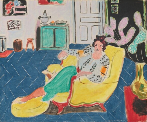 A woman wearing a pale blue and gray pattered top and turquoise skirt stretches out in an armchair in this stylized, almost square painting. The scene is loosely painted with areas of mostly flat color, especially in the background, so some details are difficult to make out. The woman is centered in the composition, and her legs stretch to our left. She has upswept dark brown hair, peach-colored skin, and her eyes, nose, and mouth are drawn with dark gray lines. Her blousy top is vertically patterned with lead-gray leaves down the front and elongated dots on the sleeves. Each sleeve also has a carrot-orange band on the upper arm. Her skirt is spearmint green, and she wears bone-white pumps. She sits in a canary-yellow armchair with red down the front of the arms and along the bottom, where the wood frame would be. One foot stretches to rest on a matching footstool, while her other leg is curled under her. The denim-blue floor tilts toward us and is covered with thin white lines in a chevron pattern. In the lower right is a red table with a bright yellow vase covered with swipes of brown and green. The vase is filled with elongated, abstract mauve-pink and mint-green shapes on slender white stems. The back wall of the room has an aqua-green cabinet to our left, which holds a silver urn and dishes of round objects. There is also a cantaloupe-orange footstool and other pieces of small furniture there, below paintings on the white wall. Above the woman is a white door with panels outlined in gray, and a section of black wall to our right has more paintings. The artist signed and dated the lower right, “Henri Matisse 40.”