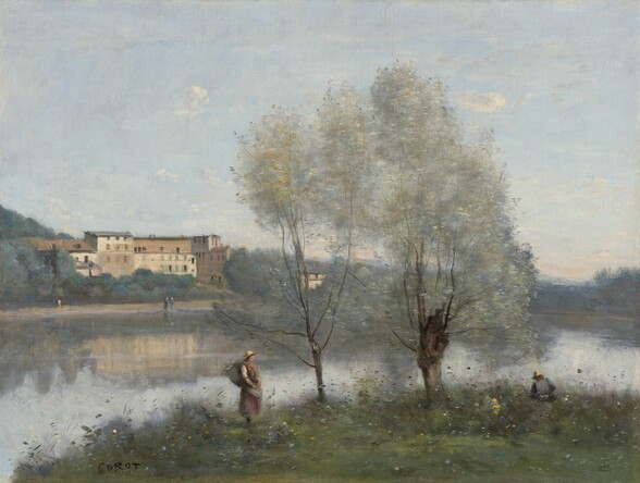 From a grassy embankment, we look across a placid body of water to a cluster of cream-white buildings on the far bank in this horizontal landscape painting. The scene is painted with blended strokes, giving it a soft and hazy look. Closest to us, dots of canary yellow, sky blue, and white suggest flowers growing on the verdant embankment. Closer to the water, two trees have ash-brown trunks and canopies like clouds of pale sage green. To our left of the trees, a light-skinned woman stands near the water with a bundle on her back. She wears a straw-yellow cap, a shin-length dress, and an apron. A second person wearing a yellow cap and a blue shirt sits facing away from us, to our right of the trees. Buildings and trees along the far bank are reflected in the pale blue water. The villa there is made up of several interconnected buildings with rectangular windows and shallow, gabled, charcoal-gray roofs. One more building is nestled into the trees that surround the complex, to our right. Painted with a few strokes of ocean blue, gray, or pale yellow, at least three people stand or walk along the far bank. The forest stretches across the horizon, which comes a third of the way up the canvas. A few small, puffy white clouds drift across the expanse of blue sky above. The artist signed the painting with black letters in the lower left corner, “Corot.”