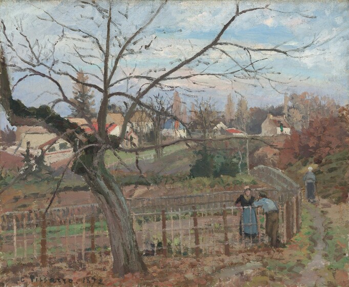 We look slightly down onto a bare, gnarled tree near a gray, dirt path, which leads back to a hamlet in this horizontal landscape painting. The scene is loosely painted with visible brushstrokes, so many details are indistinct. To our left, the gray tree trunk sways to the left as the skeleton branches of its canopy nearly span the width of the painting. The path extends from the lower right corner of the painting into the distance, around a lattice-like fence, which also runs across the width of the canvas. To our right and facing away from us, a person wearing brown pants, a sky-blue shirt, and a gray cap leans his forearms on the chest-high fence as he presumably talks with the woman standing on the other side. She wears a long navy-blue dress with a sea-blue apron and a tan hat. The land enclosed within the fence is painted with bands of peanut brown and sage green. Another woman wearing a slate-blue skirt, a sky-blue shirt, and a white cap walks away from us down the path using a cane or walking stick. To her right is a thicket of loosely painted moss-green and rust-brown foliage. Across a gully in the distance, a white picket fence separates us from the small village. The buildings have white or beige walls and pitched terracotta-red, tan, or denim-blue roofs. Beyond these structures, flax-brown trees are silhouetted against a light blue sky with fluffy white clouds. The artist signed and dated the painting in dark brown in the lower left corner: “C. Pissarro. 1872.”