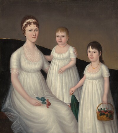 A woman and two children wear nearly matching white dresses in this vertical portrait. All three have pale skin, and they look out at us. Their floor length, short-sleeved, scoop-necked dresses are made with what looks like light, tulle-like fabric gathered just below the bust. The woman sits to our left on a dark sofa. The back of the couch curves up over her shoulders and down to our right, and off the painting. The top edge of the sofa has nail-head trim, and the wall behind it is elephant gray. The woman’s curling brown hair is pulled back behind a white headband. She has gray eyes, and her pink lips are closed. She holds a sprig of strawberries with her right hand, which rests in her lap. Her left arm, on our right, wraps around the younger child, who stands on the sofa at the center of the composition. The child has blond hair and light brown eyes, and wears a delicate, coral bead necklace. To our right, the older child stands in front of the couch. Her black hair is brushed back from her face except for bangs sweeping across her forehead. She has dark brown eyes and wears a gold-colored necklace. The older girl holds a basket of strawberries with her left hand, and rests her other hand on the pointed end of a parasol, which is tucked behind her body to our left.