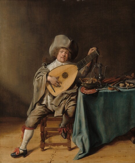A man with pale, peachy skin sits holding and tuning a lute next to a heavily laden table in this vertical portrait painting. The man’s body faces us, and he looks at us with light brown eyes under slightly furrowed brows. His round face is tipped slightly to our right, toward the neck of his instrument, so he looks out from the corners of his eyes. He has a round face, a snub nose, and his pale pink lips are closed. His dark blond mustache curls up at the ends, and he has a faint goatee. Nestled on chin-length, curly, light brown hair, his gray hat has a wide, soft brim pushed up around the crown. Much of his torso is covered by the lute but he wears a wide, white collar under a billowing, fawn-brown cloak. A cloth on his shirt or pinned under the instrument has small black dots on a white background. His knickerboxers match his cloak, and are tied with a brick-red ribbons just below his knees, over white stockings. More red ribbons are tied to the front of his black leather shoes, which have low heels. One foot rests splayed on the bare, hardwood floor. His other foot is propped up on the rail of the chair to support the instrument. One hand is braced over the strings, and he tunes the pegs with the other. He sits next to a table covered with an aquamarine-blue cloth and overflowing with kitchen utensils, smoking instruments, and food. Closest to the man, a pipe rests in an earthenware bowl filled with burning embers, which sits on a terracotta-orange plate. Near that are a silver-colored, covered ewer, a short drinking glass, a covered box with its lid open, and, to our right, a pewter plate with a roll and a knife. A wooden instrument like a small violin sits at the back of the table. The scene is lit from our left. The back wall of the room deepens from clay brown near the light to coffee brown in the upper right corner.