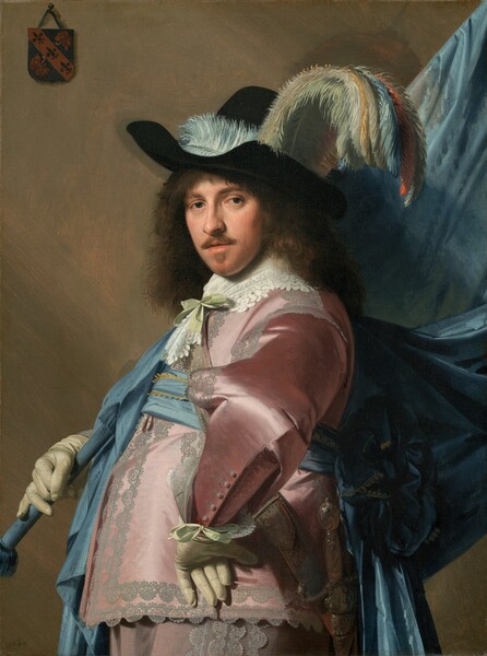Shown from the hips up, a man with pale skin and shoulder-length brown hair, wearing a long-sleeved, rose-pink satin jacket and pants, props a flagpole with a voluminous blue flag against one shoulder in this vertical portrait painting. He stands with his body facing our left in profile with his left hand on his hip, elbow jutting out at us. He turns his face to look directly at us with dark eyes. He has a straight nose, rosy cheeks, and a mustache and narrow goatee below his lips, which are slightly parted. He wears a wide-brimmed black hat generously adorned with pale blue, turquoise, pale yellow, and orange plumes. The fabric of his pink clothing reflects the light in wide patches of white, creating the impression of a satin sheen. Wide, pale gray lace lines the front opening of the jacket, the shoulders, the arms, and the sides of the trousers. His white lace collar is tied with a pale celery-green bow and a bow of the same color ties the lace cuff of the wrist we can see. A baby-blue sash wraps around his waist and is tied in a large rosette at the back. Both hands are covered with ivory-white gloves. His left wrist rests against his hip so the underside of those fingers dangle down, while the other hand supports the flag pole, which is wrapped in blue fabric. A sword hangs from his front hip. The topaz-blue fabric of the flag, or standard, drapes down from the flag pole, which extends off the top right corner of the canvas. A coat of arms, about the size of a person’s palm, hangs from a nail with a string in the upper left corner on the taupe-colored wall behind the man. The coat of arms is made up of three fleur-de-lis lined up in a diagonal band and the remaining two corners are filled with stylized lions, long tongues curling out. The artist dated the work “1640” in the lower left corner.