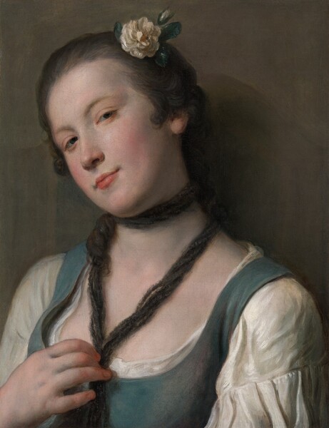 Shown from the shoulders up, a young woman with pale skin, dark hair, and wearing a muted turquoise bodice over a white shirt, peers at us against an olive-green background in this vertical portrait painting. Her shoulders are angled slightly to our left, and she tips her head away from us, over her right shoulder, to our left. With her chin jutting a bit toward us, she looks at us from the corners of her heavy-lidded, dark green eyes under arched brows. She has a straight nose, and her smooth cheeks are flushed. The corners of her closed, peach-colored lips are barely pulled back in a faint smile. Her chestnut-brown hair is pulled back, and short curls frame her face in front of her ears. She wears a white, ruffled flower with a white bud and deep green leaves in her hair over her left temple, to our right.  A dark rope or twisted fabric encircles her neck, and she gathers the long ends in her right hand, to our left, at her chest. One long curl wraps around the fabric, to our left. Her chest is smooth, and the backs of her fingers are touched with coral pink. Her low-cut, muted blue bodice is worn over a full-sleeved, white shirt pleated below the shoulders. She is lit from our left so casts a shadow against the olive-green wall to our right.