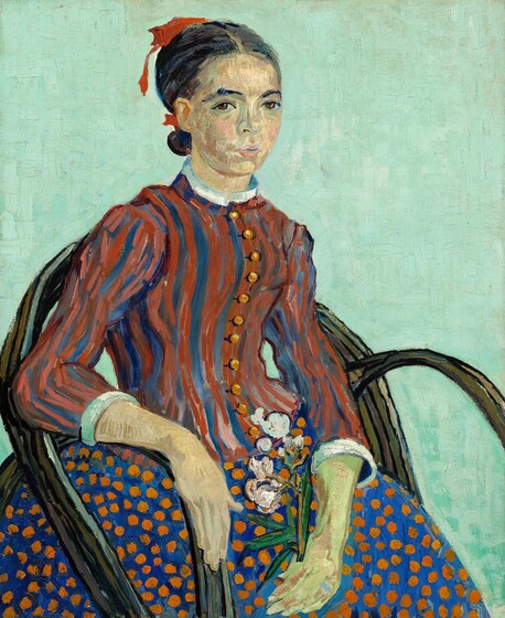Seen from about the knees up, a young woman sits in a chair angled to our right but she turns her face to look at us in this stylized, vertical portrait. Her chair has a rounded back and arms made from what looks like bent woody vines and the background is a solid field of pale aqua. Her dark hair is parted in the middle and tied at the nape of her neck with a red ribbon. Dark eyebrows curve over brown eyes and she has a rounded nose and petal pink lips are slightly parted. Her pale peach skin is tinged with green on her face and hands. Her right arm, on our left, rests along the arm of the chair and she holds a sprig of blooming oleander, with light pink flowers and green leaves, in her opposite hand resting in her lap. The bodice of her high-necked dress is striped with brick red and royal blue, and is lined with a row of round gold buttons down the front. The sleeves come down to her forearms and the cuffs and collar at her neck are white. Her full skirt is royal blue with pumpkin orange dots. The brushwork is loose throughout and individual brushstrokes are visible, especially in the stripes of her bodice and the patchy peach tones that make up her skin.