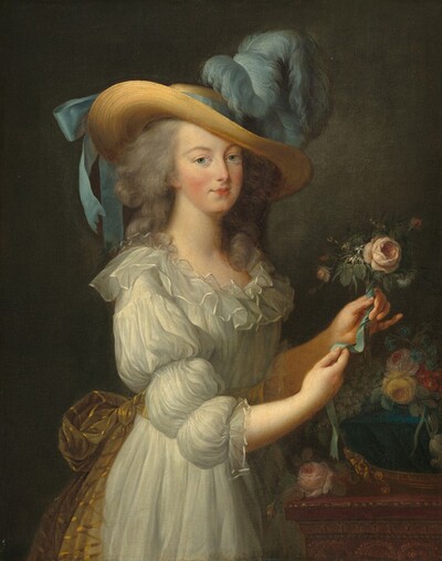 Shown from about the hips up against a dark gray background, a rosy-cheeked, light-skinned woman stands before a wooden table as she arranges flowers in this vertical portrait. Her body is angled to our right, and she turns to look at us with clear blue eyes under curving brows. She has a straight nose, and her small bow lips are closed. Her gray hair is loosely bound, and curls fall over her shoulders. She wears a white muslin dress with puffed sleeves and blousy ruffles around the neckline. Her dress is gathered at her waist with a sheer, gold-striped sash. The wide brim of her straw hat curves down across her forehead, and a robin’s egg-blue ribbon is tied around the crown into a bow at the back. Puffy feathers of the same blue billow up and forward at the front of the hat. She stands at a wooden table that extends off the right side of the canvas. A deep blue bowl sitting on bright gold feet holds pale pink, yellow, crimson-red, and aquamarine-blue flowers. The woman holds up a pink flower, perhaps a rose, in her left hand and ties it with a blue ribbon.