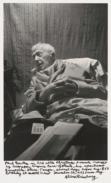 Paul Bowles in bed with Christmas presents brought by biographer Virginia Carr of Atlanta, his apartment Immeuble Itesa Tangier, several days before his 83