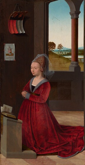 A pale-skinned woman wearing a voluminous, garnet-red, long-sleeved dress kneels at a low lectern in a dark gray room, in front of a window opening onto a grassy landscape in this vertical painting. The woman’s body is angled to our left, and she looks off in that direction. She has a high forehead, thin, arched brows, light brown eyes, a round jawline, and her pale lips are closed. A cone-shaped, gold headdress covers her hair. On the headdress, pearls mark the intersections of a grid made by lines of white dots, and there is a red flower in the center of each square. A gauzy, translucent veil covers her forehead to her brows and hangs off the back of the headdress. Another sheer cloth covers the woman’s chest down to the neckline of her dress, which is edged with gray fur. A gold-colored belt gathers the full skirt, which pools on the ground around and behind her. Gray cuffs cover the backs of her hands to her fingers, which touch in prayer in front of her waist. She wears a gold ring on the ring finger we can see. The gray lectern at which she kneels is cut off by the left side of the painting. Pages flutter across an open book laid on the angled top of the lectern. The floor beneath is a checkerboard of veined, muted, pale pink and ivory-white tiles. A print showing a crowned woman holding two more crowns is affixed to the gray wall with red dots, presumably wax. In the print, the woman’s robe has been colored pale pink, and she stands on bronze-colored grass. Words printed in red and black letters beneath the woman are partially legible, and include “O s a elisab. O.” Above the print hangs a shield-like object that curls away from the wall in a shallow C shape. The shield is rectangular and made up of four vertical, fluted sections. Two to the left are bright red and the two to the right are white. In the top third of the shield, a stylized black bird extends its wings against a copper-red background. The shield hangs from a gray cord on a substantial iron nail. Behind the kneeling woman, a window opening is bisected by an pair of columns. The view beyond shows grassy hills rolling back to spindly trees, a body of water reflecting the pale, nearly white sky, and distant trees and mountains, blue along the horizon. Tiny in the sky, seven birds, presumably geese, fly in a lopsided V near the top left corner of the opening.