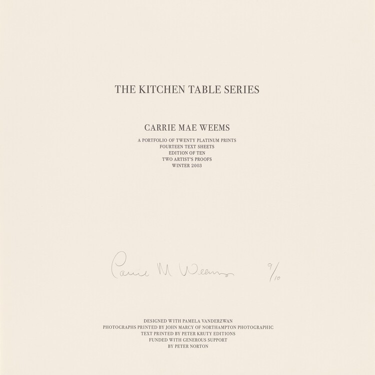 Twelve lines of black text in all capital letters are printed on a square, beige-colored sheet of paper. The lines are centered down the page and divided into four groups set in progressively smaller type sizes. Near the top, the largest text reads, “THE KITCHEN TABLE SERIES.” In smaller text below, “CARRIE MAE WEEMS.” Immediately below that, again in smaller text, “A PORTFOLIO OF TWENTY PLATINUM PRINTS, FOURTEEN TEXT SHEETS, EDITION OF TEN, TWO ARTIST’S PROOFS, WINTER 2003.” The remaining text is printed in five lines at the bottom center of the sheet: “DESIGNED WITH PAMELA VANDERZWAN, PHOTOGRAPHS PRINTED BY JOHN MARCY OF NORTHAMPTON PHOTOGRAPHIC, TEXT PRINTED BY PETER KRUTY EDITIONS, FUNDED WITH GENEROUS SUPPORT, BY PETER NORTON.” Between the text at the center of the sheet and the five lines along the bottom, the artist signed the sheet in graphite: “Carrie M. Weems 9/10.”