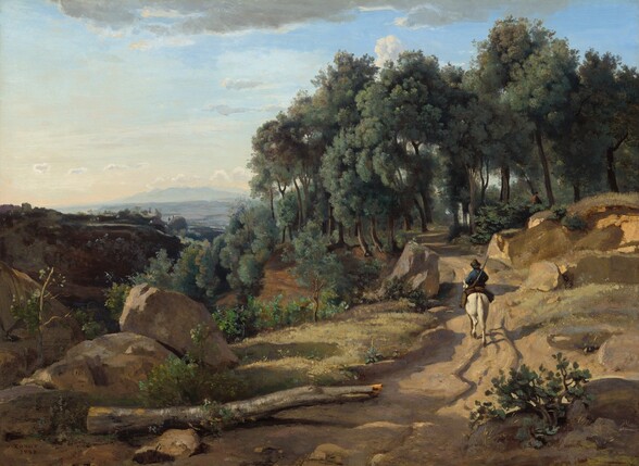 We look slightly down onto a man riding a white horse away from us on a dirt road winding through a sun-drenched, rocky landscape in this horizontal painting. The man wears a cobalt-blue jacket and soft black hat, and the rutted path he follows cuts along the side of a steep hill or mountain peak. The path extends from the bottom center of the composition and stretches up the right side toward a grove of sage-green trees with brown trunks. The trees fill the upper right half of the composition, and the tallest ones almost brush the top edge of the canvas. Closer examination reveals a person in a brown coat in the shade of the trees, just off the path ahead. Seen from the hips up, they face our right in profile. Scrubby plants, bushes, and saplings in tones of kelly, pea, and fern green sprout among the boulders that line the road. A broken, bare, segment of a silvery-gray tree trunk lies along the path to our left. Lit with brilliant sunlight coming from the lower left, the horse and rider, and the boulders lining the path cast mauve-purple shadows along the ochre-brown road. The rocky terrain to the left dips down into a valley and is in deep shadow. A mountain across the valley is also deep in shadow, painted dark brown. The landscape becomes steel gray and then hazy blue as it recedes into the deep distance. The horizon comes about halfway up the canvas. Gray and white clouds are scattered across a sky that deepens from pale blue along the top edge to nearly white at the horizon. The artist signed and dated the work in the lower left, “COROT. 1838.”