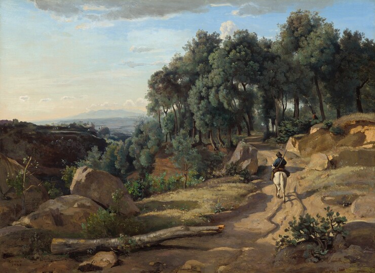 We look slightly down onto a man riding a white horse away from us on a dirt road winding through a sun-drenched, rocky landscape in this horizontal painting. The man wears a cobalt-blue jacket and soft black hat, and the rutted path he follows cuts along the side of a steep hill or mountain peak. The path extends from the bottom center of the composition and stretches up the right side toward a grove of sage-green trees with brown trunks. The trees fill the upper right half of the composition, and the tallest ones almost brush the top edge of the canvas. Closer examination reveals a person in a brown coat in the shade of the trees, just off the path ahead. Seen from the hips up, they face our right in profile. Scrubby plants, bushes, and saplings in tones of kelly, pea, and fern green sprout among the boulders that line the road. A broken, bare, segment of a silvery-gray tree trunk lies along the path to our left. Lit with brilliant sunlight coming from the lower left, the horse and rider, and the boulders lining the path cast mauve-purple shadows along the ochre-brown road. The rocky terrain to the left dips down into a valley and is in deep shadow. A mountain across the valley is also deep in shadow, painted dark brown. The landscape becomes steel gray and then hazy blue as it recedes into the deep distance. The horizon comes about halfway up the canvas. Gray and white clouds are scattered across a sky that deepens from pale blue along the top edge to nearly white at the horizon. The artist signed and dated the work in the lower left, “COROT. 1838.”