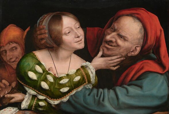 A smiling young woman and an elderly man with exaggerated features embrace and gaze into each other’s eyes while a person dressed in the orange costume of a fool lurks behind them to our left in this horizontal painting. All three have pale skin and are shown from the chest up behind a ledge or tabletop against a black background. The older man to our right wears a dark teal-blue garment and a bright crimson-red head covering that drapes over both shoulders. Wrinkles and age spots cover his face, which is accentuated by a bulbous nose and a leering smile that exposes missing teeth. His arms reach out and encircle the woman to our left. Cradling the right side of her head with his right hand, his left arm reaches across to her upper body, his thumb visible at her breast. A blue and gold band holds the woman’s auburn-brown hair back. A white shift peeks through the slashed sleeves of her emerald-green, gold-trimmed gown. She reaches toward the elderly man with her right arm, her hand holding his chin. Her left arm reaches across her body under his arm and she holds a leather pouch in that hand. A man wearing an orange cap with asses’ ears reaches for the pouch, eyes crossed and his tongue protruding from the side of his mouth. Playing cards and coins lie on the ledge to our left.