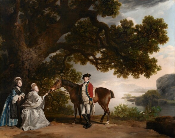 A man stands with one arm resting over the back of a chestnut-brown horse as two women approach the animal in this horizontal portrait painting set in a landscape. The people have pale skin, dark eyes, and ash-brown or gray hair. At the center of the composition, the cleanshaven man stands with his body angled to our left as he looks off in that direction. He has a rounded nose, a dimple in his slight double chin, and he smiles faintly. A black tricorn hat sits on his gray hair, which curls up over his ears. His uniform has a long, pearl-white vest over a high, bright-white collar. His knee-length red coat is open, and the side closer to us is tucked back behind a sword hanging on that hip. The coat is lined with navy blue and gold down the front and around the cuff we see. The vest and coat have gold-colored buttons, and a gloved hand rests on the scabbard by his side. He wears white britches and knee-high, black boots with spurs. One ankle crosses in front of the other as he leans gently against the horse. The animal bends one back leg to rest along the front edge of its hoof as it reaches its muzzle forward, toward the women to our left. One woman sits in a wood armchair in front of the horse as she holds some pink flowers to the animal’s nose. She has a bumped nose, dark brows, and her delicate, pale pink lips are parted. Her hair is teased high and covered at the back with a white cloth. A voluminous, pearl-white, hooded shawl covers all of her upper body except the proffered hand. The lace edge of the white skirt puddles on the dirt ground. Behind her, the second woman leans over her crossed forearms, which rest on the back of the chair. This second woman has large eyes and delicate features. The top of her hair is also covered with a cloth, and she wears a black choker and a black apron over a sapphire-blue and white dress. A thick-trunked tree behind the women fills the left half of the composition, and its dark canopy reaches almost across the top half of the painting. A few plants line the far side of the dirt ground to our right. An expanse of silvery water curves like a C around a rocky promontory in the distance, also to our right. Smoke-gray mountains, hazy in the distance, stretch across the horizon, which comes about a third of the way up the composition. Some steel-gray and pale peach clouds cover much of the ice-blue sky.