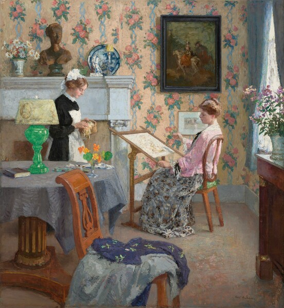 In a wallpapered room with a window to our right, a woman to our right sits at a frame holding needlework while a woman wearing a black and white maid’s outfit stands facing her, to our left, in this nearly square painting. Both women have pale complexions and light brown hair loosely pulled up. The woman doing needlework faces our left in profile. She wears a pastel pink shawl or blouse with a long skirt patterned with gray, black, and white. She looks at her work as she pulls a needle and thread with her right hand, farther from us. The needlework is stretched on an easel-like frame so the top can be angled toward the seamstress. The maid wears a white cap and a white apron over a long-sleeved, black dress. She holds a small basket and seems to pull out or sort through yellow and white thread. The wall behind the women is patterned with bunches of dusky-pink flowers linked by baby-blue ribbons, against a field of pale, golden yellow. Sunlight pours through the window to our right, which is framed with periwinkle-blue curtains. On a table along that wall near us, a vase holds a bunch of leggy, magenta-purple flowers. A painting hanging over the seated woman’s head is done with muted tones of brown, blue, and brick red, and it shows a person on horseback in a landscape. The maid stands in front of a white mantlepiece that holds, from left to right, a white ceramic vase with white and yellow daises, a bronze-colored, sculpted bust of a woman, and a blue and white porcelain plate or bowl tipped up so we see the inside. A wood table with a wide, pedestal foot stands between us and the maid. It is covered with a periwinkle-blue cloth and holds a glass vase with yellow and orange flowers, a sea-glass green lamp with a white shade, a book, and possibly some papers. Lavender and royal-purple cloth is strewn across a wooden chair immediately in front of us, at the bottom center of the painting. The floor is painted with blended shades of mauve, pink, and tan. The artist signed the work with dark paint in the lower right corner: “Gari Melchers.”